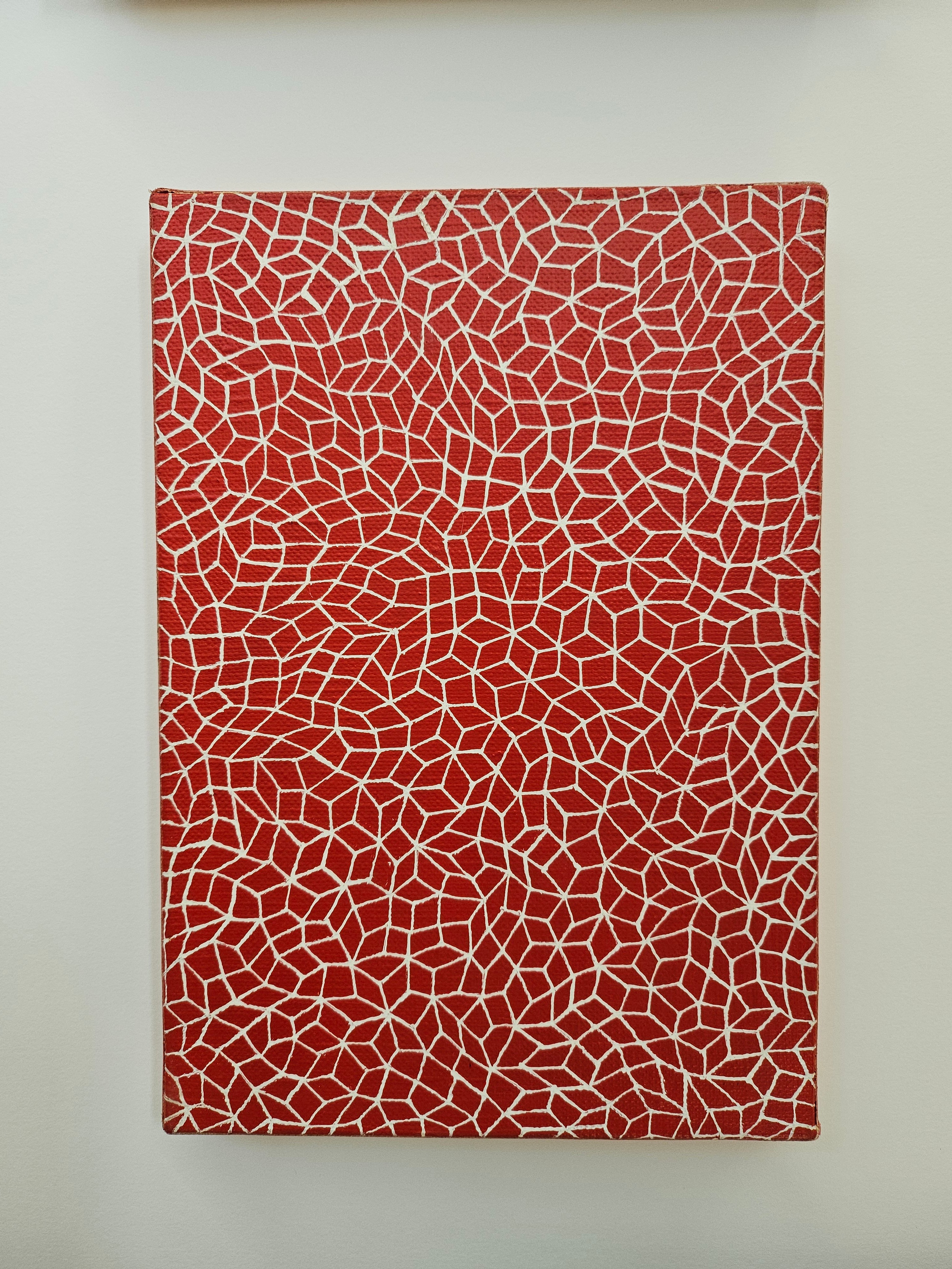 A red canvas covered in a white hand-painted mosaic tessellation