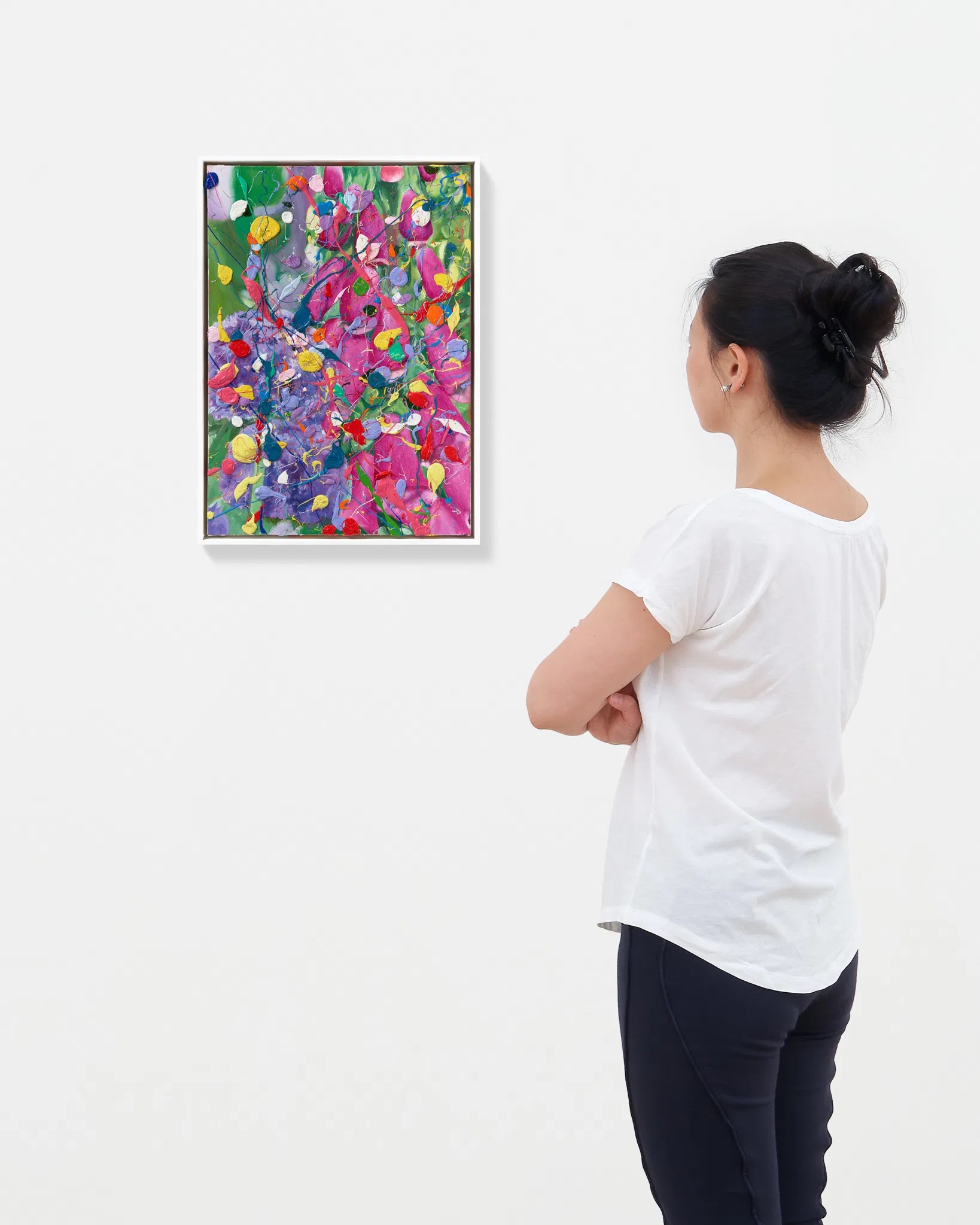 A collector viewing framed works installed on a gallery wall before a sale